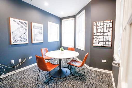 A room with a round table and chairs.