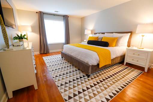 A bedroom with a bed, nightstand, and lamp.