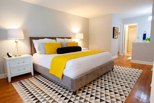 A bedroom with a bed, nightstand, and lamp.