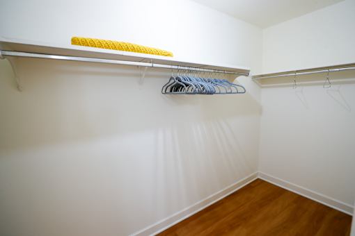 A white closet with a yellow and blue hanger.