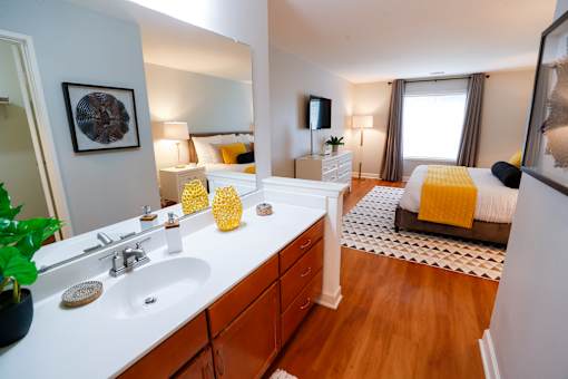 A bathroom with a white counter top and a white sink.