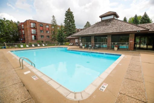 a pool with a brick building in the background