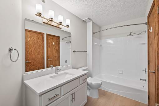 A white bathroom with a sink, toilet, and bathtub.