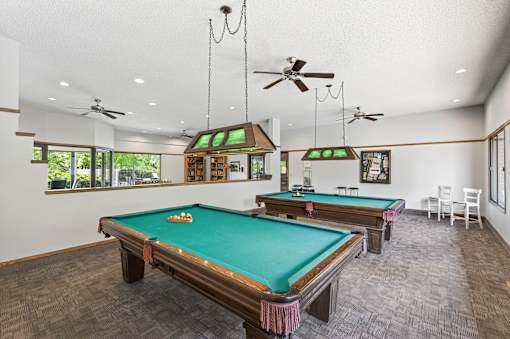 A room with a pool table and a billiard table.
