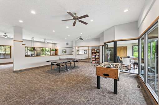 A room with a ceiling fan and a table with a wooden box on it.