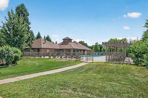 A house with a brown roof and a pool in the backyard.
