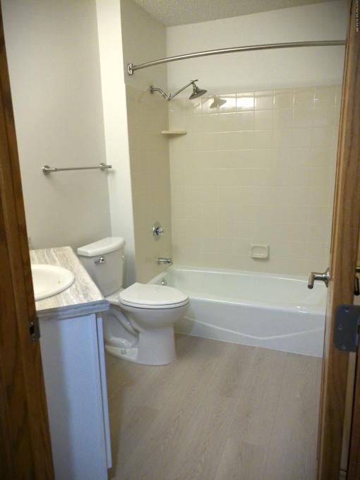 A white toilet and sink in a small bathroom.