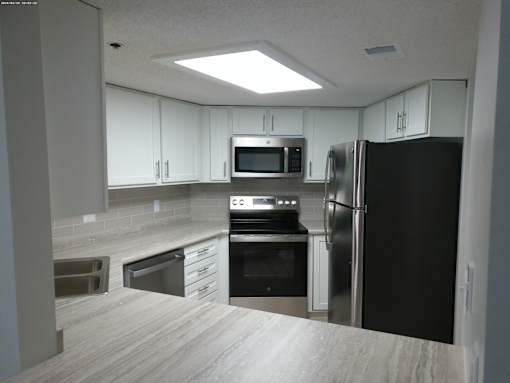 A kitchen with a black refrigerator, stove, and oven.