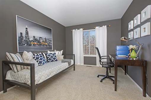 A living room with a couch, chair, and a large picture of a city skyline on the wall.