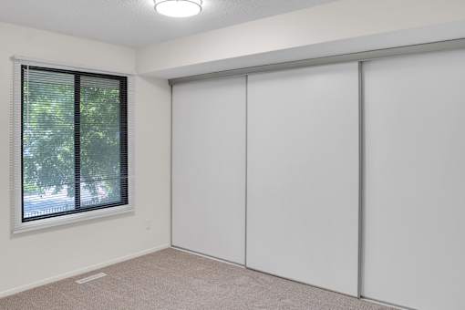A room with a window and sliding doors.