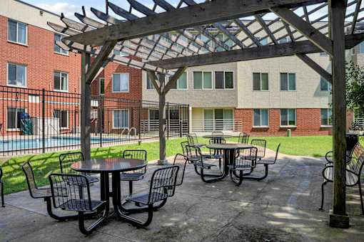 A patio with a table and chairs under a pergola.