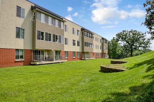 A long building with a green lawn in front.
