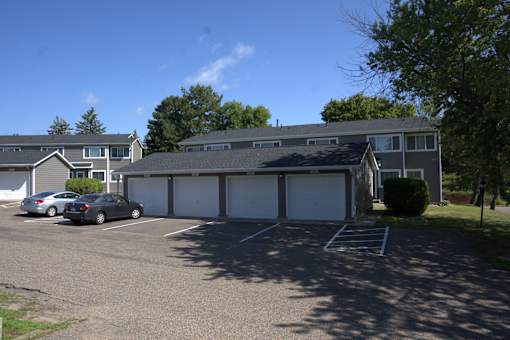 A parking lot with cars and a building in the background.