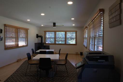 A room with a table, chairs, and a printer.