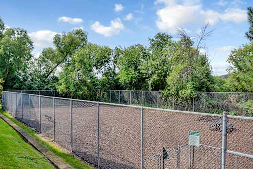 A chain link fence surrounds a tennis court.