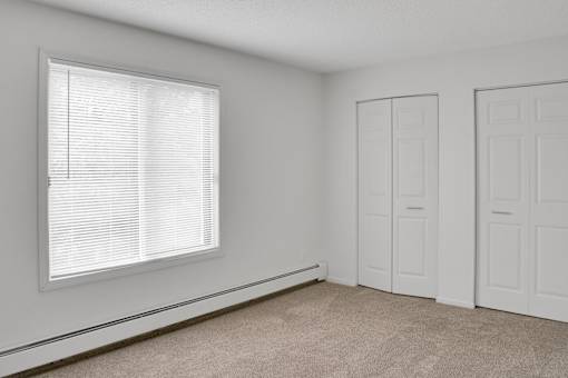 A room with a window and two doors.