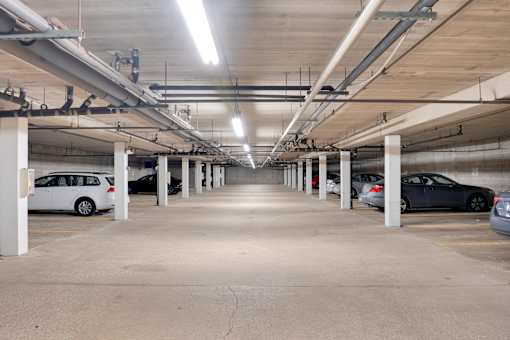 A parking garage with multiple cars parked.