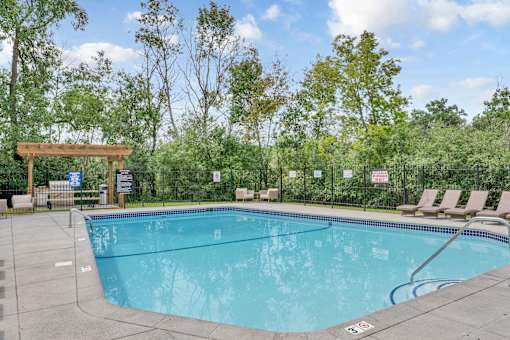 A large outdoor swimming pool surrounded by trees.