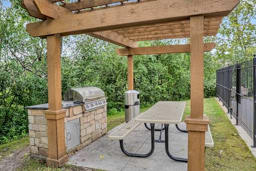 A wooden pergola with a picnic table underneath it.