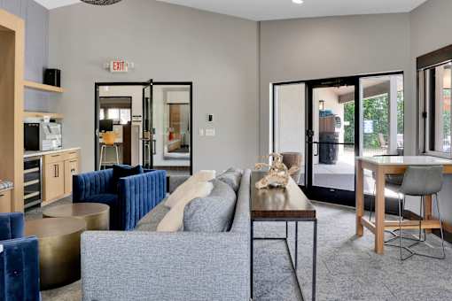 A living room with a grey couch and a dining table.