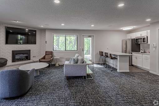 A modern living room with a grey carpet and a fireplace.