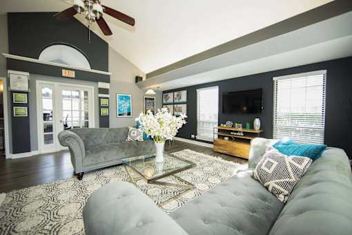 A living room with a grey couch and a coffee table with flowers on it.