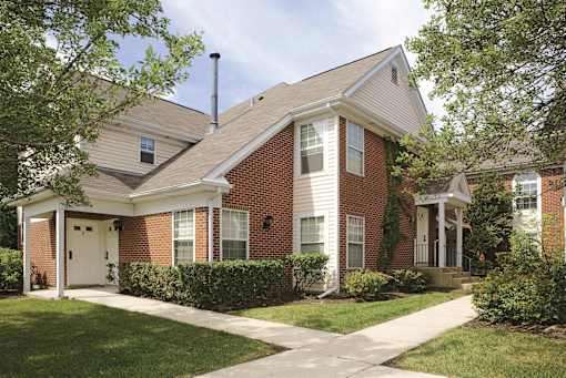 A red brick house with a white door and windows.