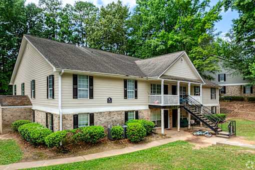 A house with a front yard and a deck.