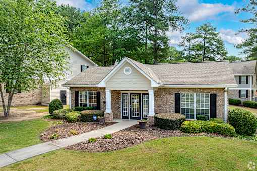 A house with a front yard and a tree.