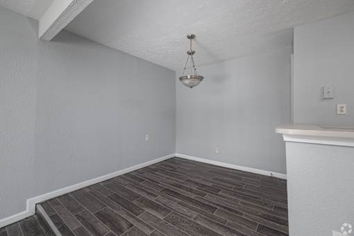 A room with a wooden floor and a chandelier hanging from the ceiling.