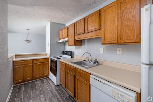 A kitchen with wooden cabinets and a white refrigerator.