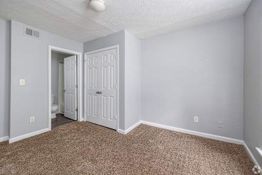 A room with a carpeted floor and a white door.