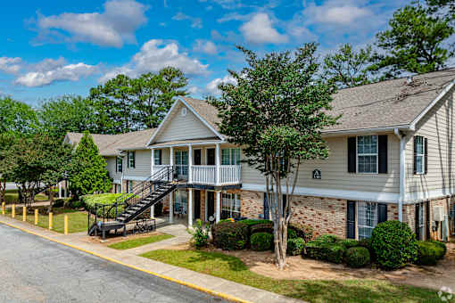 A residential building with a tree in front.