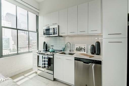 A modern kitchen with white cabinets and stainless steel appliances.at 1600 Callowhill, Philadelphia, PA 