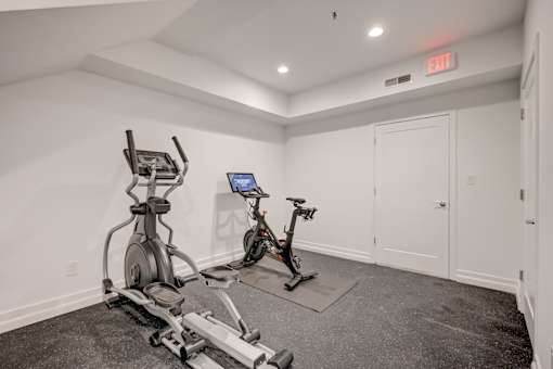 A room with a treadmill and an exercise bike.