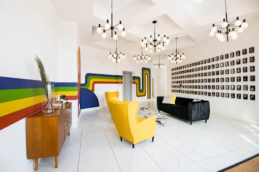 A room with a yellow chair and a black bed.