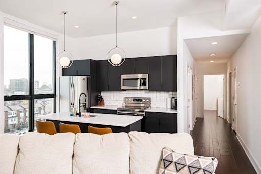 A modern kitchen with a white sofa in front of it.