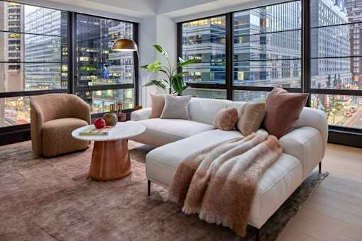 A living room with a white couch and a brown chair.