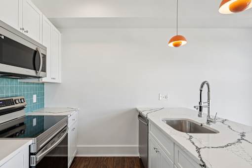 A kitchen with a white counter top and a sink.