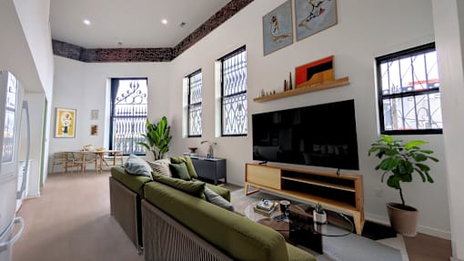 A living room with a green couch and a flat screen TV.
