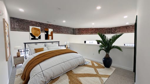 A bedroom with a large bed and a plant.