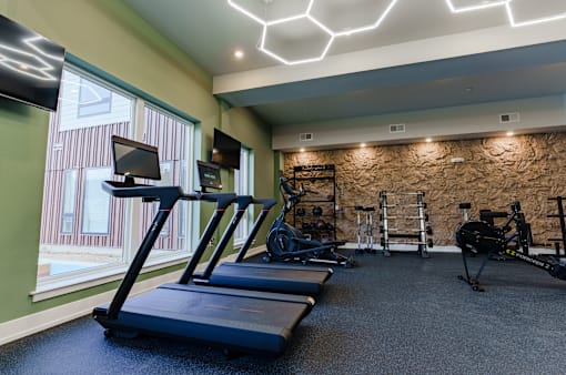 A gym with treadmills, weights, and exercise equipment at The Hawthorn.