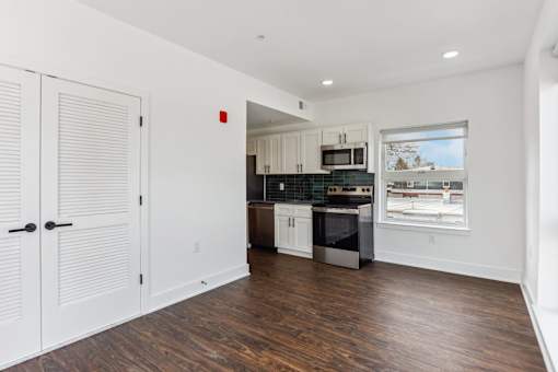 A kitchen with white cabinets and a black stove top oven.