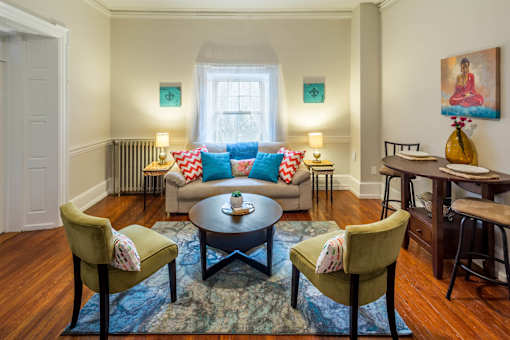A living room with a sofa, two chairs and a table.
