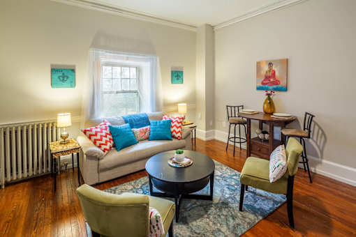 A living room with a couch, chairs, and a table.