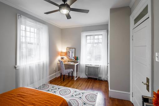 A bedroom with a bed, desk, and chair.