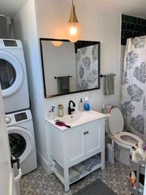 A small white bathroom with a washer and dryer.