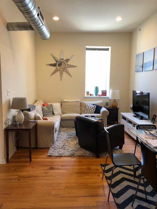 A living room with a couch, a chair, a table, and a television.