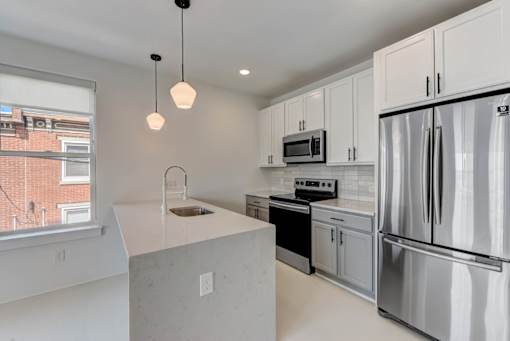 A modern kitchen with stainless steel appliances and white cabinets.