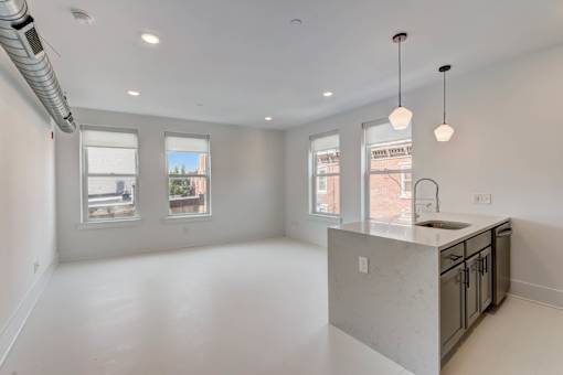 A kitchen with a large island and pendant lights.